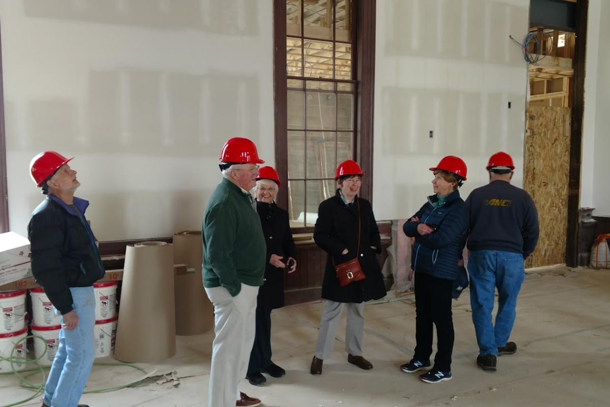 Seniors Wear Red Hard Hats While Touring Town Hall during Construction