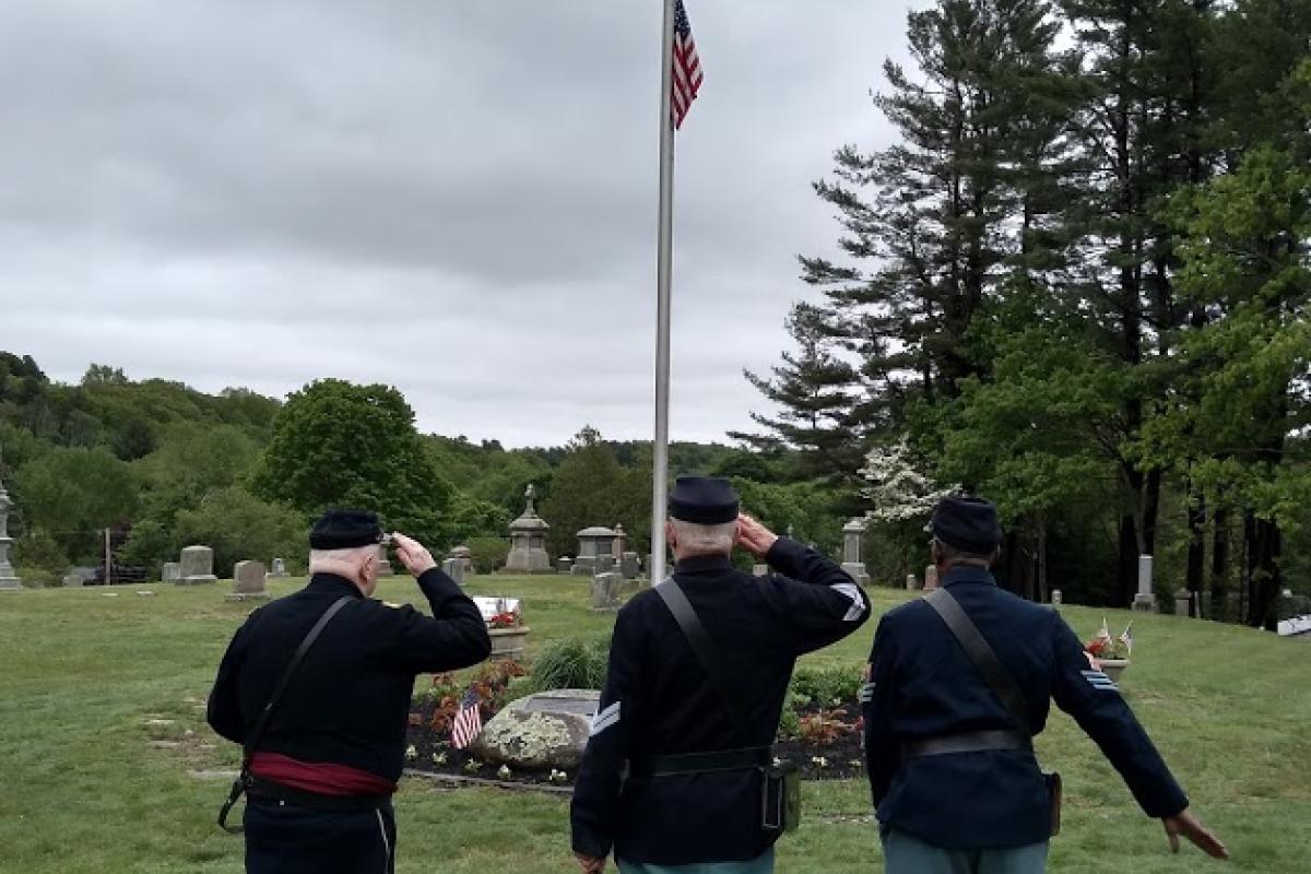 Three Men in Civil War Period Uniforms Salute the Flag Flying at Half Mast during a Grave Recognition Ceremony