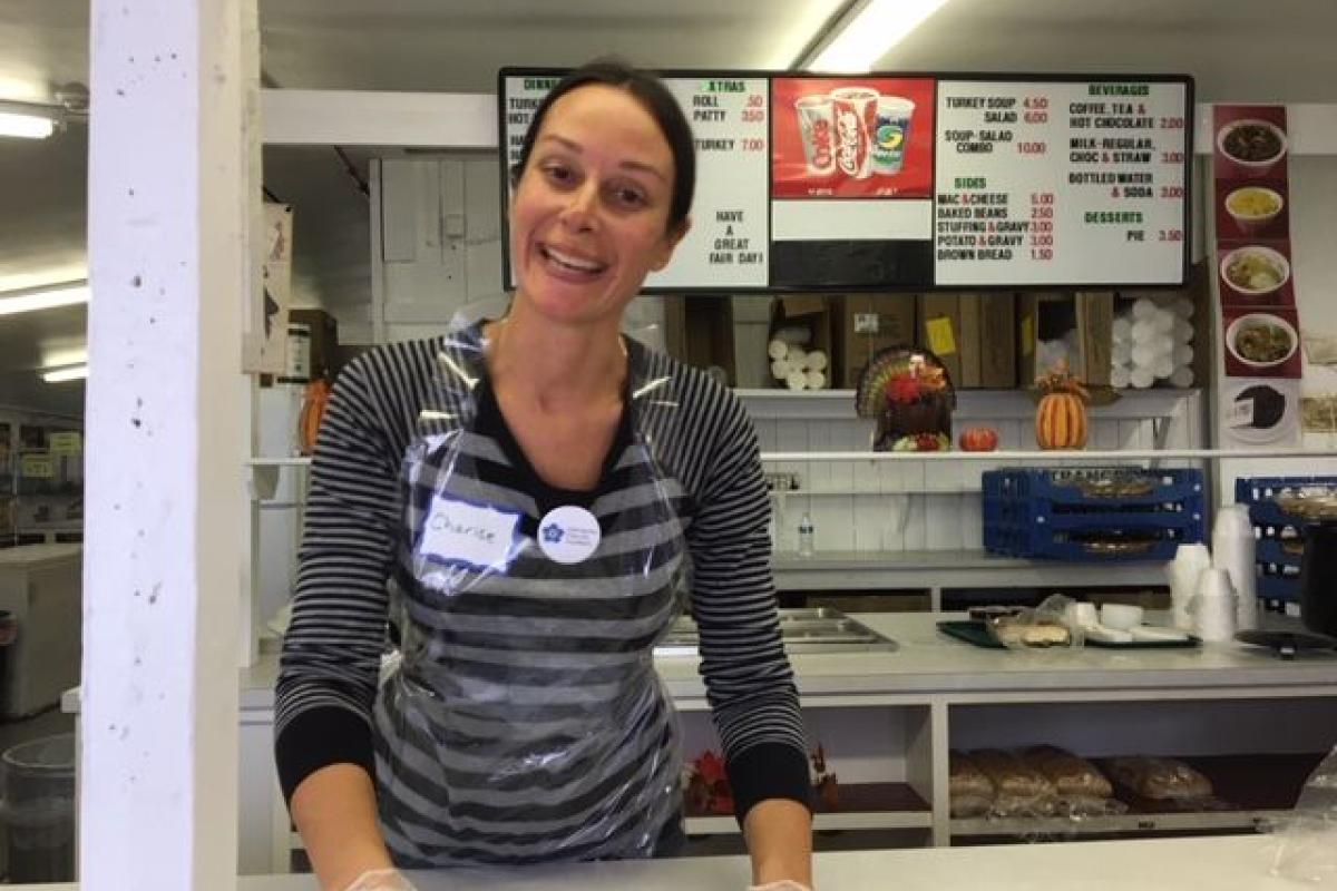 A Smiling Woman Greets Patrons at a Counter