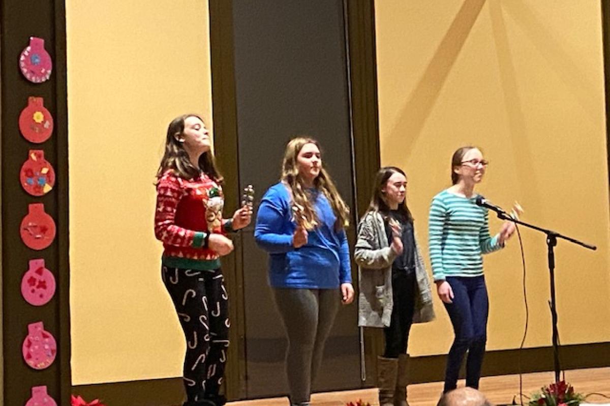 Four Teenagers Perform On Stage during a Holiday Party