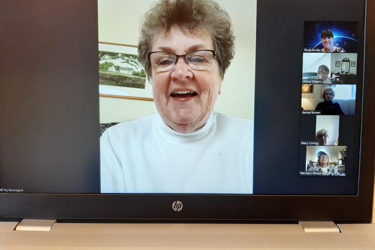 A woman smiles during a Zoom meeting