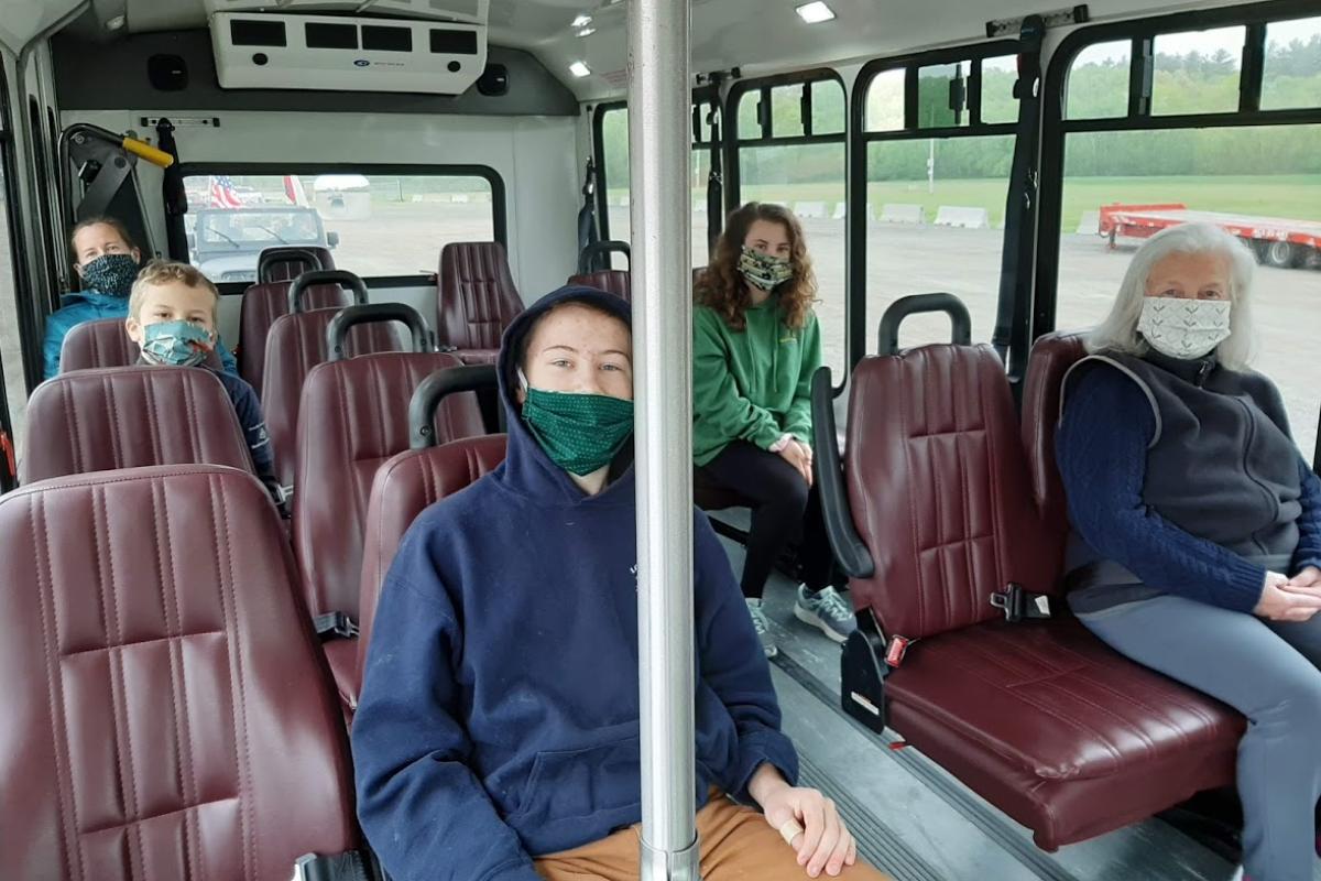People on small bus wearing masks