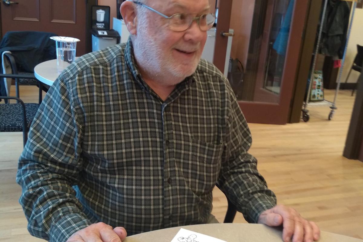 A Man Smiles After Finishing His Homemade Card
